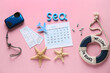 © Pixel-Shot - Calendar with word SEA, tickets and beach decor on pink background. Summer vacation concept
