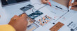 © InfiniteFlow - Two individuals engage in collaborative interior design planning, discussing colorful material swatches and an architectural layout on a modern workspace table. SACTR