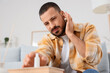 © Pixel-Shot - Young man with ear pain taking drops from table at home