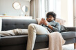 © peopleimages.com - Relax, texting or man with phone on sofa, check social media or browsing internet for online book. Reading app, message notification or person with mobile in home, chat response or search for ebook