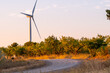 © yaqui_villegas - Sunset landscape with wind turbine beside road trail and field in the Terra Alta region of Catalonia Spain showcasing renewable energy