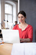 © Westend61 - Woman using laptop on table in office