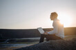 © Westend61 - Mature businessman using laptop on a disused mine tip at sunset