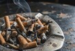 © kamyuga - Close up macro photography of pile of dirty cigarette butts and ash in ashtray showing addiction concept