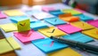 © FACTORY GRAPHICA  - A colorful array of sticky notes with checkmarks and a pen arranged on a table, symbolizing tasks and progress.