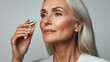 © Sakson - Anti aging serum application by mature woman studio setting lifestyle content close-up view skincare concept