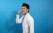 © Restu - Muslim man eating dates on blue background