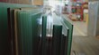 © SerPak - Stacked glass sheets are organized in a warehouse, showcasing various thicknesses and sizes. Industrial storage and material handling.