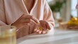 © Mary - Woman taking dietary supplements while sitting at kitchen table