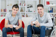© auremar - happy young brothers playing video games one on wheelchair