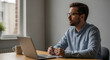 © FATIHAKHANDOKER - A man works on his laptop at a desk with a cup of coffee nearby.