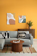© Pixel-Shot - Comfortable sofa, coffee table and picture hanging on yellow wall in living room