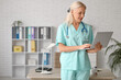 © Pixel-Shot - Mature female doctor working with laptop in clinic