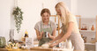 © Pixel-Shot - Mature woman with her daughter preparing dough in kitchen. Mother's Day celebration