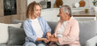 © Pixel-Shot - Senior woman with her granddaughter holding hands on sofa at home
