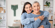 © Pixel-Shot - Happy young woman hugging her grandmother at home