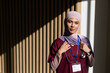 © Wavebreak Media - African American woman posing in clinic by slatted wall wearing scrubs stethoscope ID, copy space