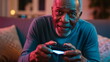 © xuxu - African american man playing video game with wireless controller. Senior gamer enjoying modern entertainment technology concept digital game.