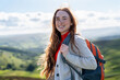 © Iryna - Woman enjoys hiking in the mountains with a backpack on a sunny day in nature