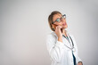 © Nenad - Female doctor consulting patients remotely by phone, isolated on white