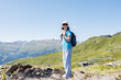 © Elena Medoks - Young hiker conquering mountain peak, embracing breathtaking alpine scenery