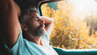 © Bonsales - Mature man with closed eyes relaxing inside car, arms behind head, feeling warmth of sunshine and autumn air