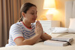 © New Africa - Religion. Woman with Bible praying at home