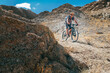 © Soloviova Liudmyla - Mountain biker riding bicycle on narrow cliffy crossbike route in Ladakh India featuring steep rocky slopes and massive barren mountain ridges under blue sky background area in Himalayan desert