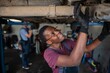 © Jelena - Young african female mechanic repairing car in a workshop