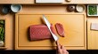 © ThePixLab - Precise overhead view of a mirror-polished yanagiba knife drawing a clean slice through ruby-red marbled tuna loin on a blonde hinoki cutting board with visible muscle fiber grain