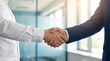 © CuteBee - A firm handshake between two professional individuals, one in a white shirt and the other in a blue suit, symbolizing a successful business agreement.
