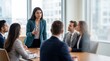 © ryker - Confident Indian woman leading business meeting in modern office, presenting ideas to attentive colleagues with professional attire and collaborative energy