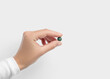 © Iryna_B - Hand holding a small round green detox pill