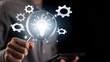 © Anwesha Dey - Businessman holding magnifying glass with glowing light bulb and question marks, representing problem solving, finding solutions, critical thinking, and innovative decision making.