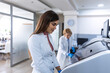 © Graphicroyalty - Portrait of a young female scientist using automated medical equipment in a lab, healthcare and medicine concept. Lab technician in white coat working with high-tech diagnostic machinery at clinic.