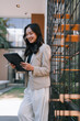 © Tj - Asian businesswoman using digital tablet with stylus outdoors