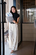© Tj - Businesswoman smiling reviewing business documents on clipboard