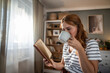 © Migma_Agency - Young woman enjoying reading book with hot drink at home