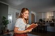 © Migma_Agency - Woman reading a book and drinking coffee at home