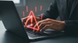 © Kunal - Person typing on laptop with red warning symbol indicating error or alert