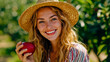 © Nikname - A smiling woman in a straw hat holding a red apple