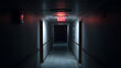 © Jean - Panneau de sortie de secours illuminé dans un couloir sombre d'un bâtiment à la fin de la journée
