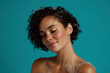 © Mind - Serene beauty portrait of young african american woman smiling with closed eyes and black curly hair showing clear skin and bare shoulders teal blue background expressing calm relaxation and joy