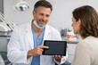 © Anat art - Dental Professional Shows Dental Information on Tablet to Patient in a Dental Office During a Consultation