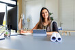 © Wavebreak Media - Indian woman sitting at office desk organizing architectural blueprints by computer and tablet