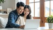 © RADEA STUDIO  - Happy Asian couple using laptop at home.