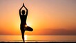 © Adnan - Silhouette of a woman practicing yoga tree pose at sunset on a beach, embodying peace and balance.