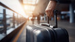 © Broccolini - close-up of hand pulling pink suitcase at airport platform, traveler walking with luggage at railway station, minimalist travel concept with person holding suitcase handle