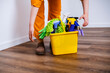 © 5ph - Woman housemaid placing yellow bucket with chemicals on floor. Preparation for professional cleaning service and deep home sanitation.