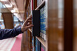 © Smallroombigdream - Hand selecting book from wooden library shelf. Legal research concept, attorney reference material, system study, academic knowledge and professional legislation archive.